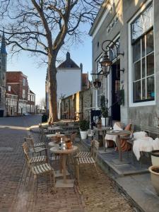 een terras met tafels en stoelen voor een gebouw bij Studio Bourbon in Veere