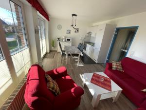een woonkamer met een rode bank en een tafel bij Ferienwohnung Hoffmann in Hooksiel