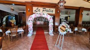 a wedding arch in a restaurant with a red carpet at Pensiunea La Palia in Iaşi