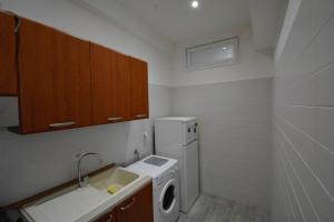 una piccola cucina con lavatrice e lavandino di Appartamento Vistamare 20 a Bari