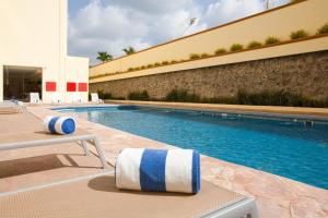 uma piscina com duas espreguiçadeiras ao lado de um edifício em Hípico inn Hotel em Poza Rica de Hidalgo