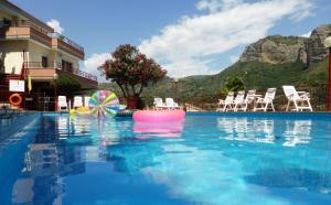 a swimming pool with chairs and a pool noodle in the water at Residence Green Park in Ventimiglia