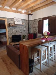 - un salon avec une table en bois et un canapé dans l'établissement Casa Rural Güilones, Parque Natural de Ponga, à Sobrefoz