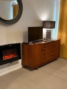 a living room with a tv and a fireplace at Atlantic apartment in Sidmouth
