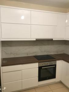 eine Küche mit weißen Schränken und einem Herd mit Backofen in der Unterkunft Gkiko’s Guest House in Qeparo + 2 Fotos