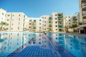 a swimming pool in front of some apartment buildings at Bugibba Deluxe Penthouse with terrace & communal swimming pool in St. Paul's Bay
