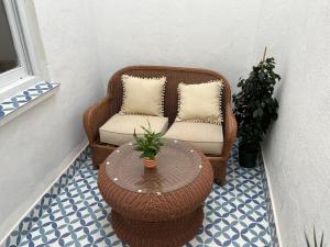 uma cadeira de vime e uma mesa e uma cadeira e uma mesa em Alzira bonita Apartamento B con patio, la Casella em Alzira