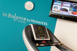 a cell phone in a fitness machine next to a tv at Novotel Suites Lille Europe in Lille