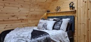 a bedroom with a bed in a wooden wall at Loch Ewe Luxury Pods in Mellon Charles