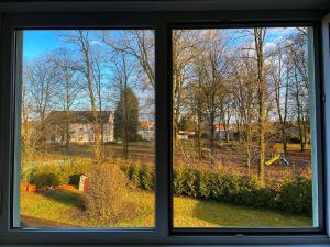 ein Fenster mit Blick auf ein Feld und Bäume in der Unterkunft Hotel Le Ronchamp in Ronchamp