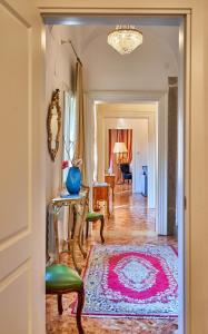 um corredor que leva a uma sala de estar com um tapete rosa em venezianischer Palazzo mit kostenlosen WLAN nähe Markusplatz em Veneza