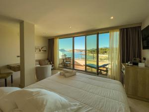 a bedroom with a large bed and a view of the ocean at La Sort Boutique Hotel in Moraira