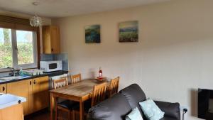 a living room with a table and a kitchen at Detached Bungalow in North Cornwall in Bodmin