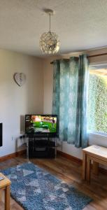 a living room with a flat screen tv in a room at Detached Bungalow in North Cornwall in Bodmin