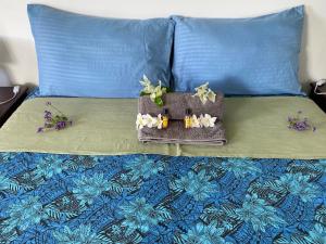 a purse on top of a bed with blue pillows at Anaiva Lodge Bora in Bora Bora