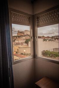 a room with two windows with a view of a city at Casa EL CASTILLO,a 5 kilómetros de la playa in Mazarrón