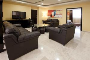 a living room with two couches and a flat screen tv at Hípico inn Hotel in Poza Rica de Hidalgo