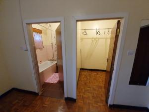 a hallway with a bathroom with a tub and a toilet at Thayo Place in Nyeri