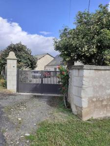 a fence with a black gate in a yard at Le Gîte de Martine et Marc in Sazilly
