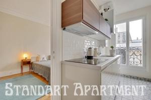 een keuken met een wastafel en een bed in een kamer bij Eiffel Tower view Rose, apartment #2 in Parijs +22 foto's