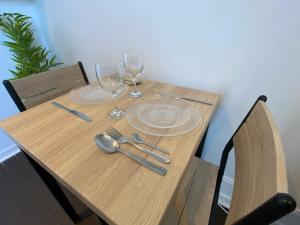 - une table en bois avec des verres et des ustensiles dans l'établissement Le Petit Cerf 3 / Proche Disney / Paris / Wifi, à Meaux