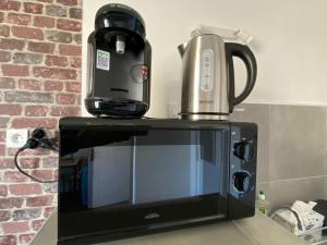 a coffee maker sitting on top of a microwave at Le Petit Cerf 3 / Proche Disney / Paris / Wifi in Meaux