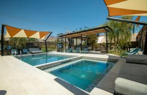 a swimming pool with a patio furniture and an umbrella at Solar Madariaga Hotel in Vicuña