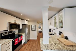 a kitchen with white cabinets and a black counter top at Queen Anne Escape in Seattle