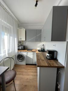 a kitchen with white cabinets and a table with a microwave at Cozy Studio 1 Bedroom nearby Value Center Mall in Zalău