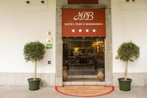 a hotel entrance with two trees in front of a store at Hotel Parco Borromeo - Monza Brianza in Cesano Maderno