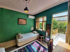 a green room with a bed and a window at hostel vague in Antalya