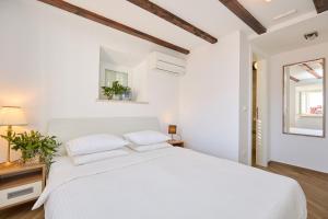 Un dormitorio blanco con una cama blanca y una ventana en Heritage Vista, en Dubrovnik