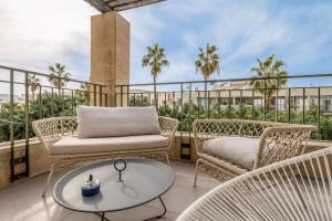 a balcony with wicker chairs and a glass table at Rooftop 2 Luxury Apartment By Nimizz in Tel Aviv