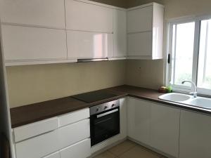 eine Küche mit weißen Schränken und einer Spüle und einem Herd in der Unterkunft Gkiko’s Guest House in Qeparo