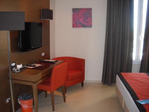 Habitación con escritorio, silla y cama. en Hotel Tiber en Fiumicino