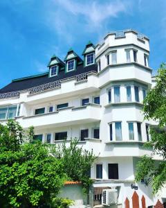 um edifício branco com um telhado preto em HOTEL THE WHITE HOUSE Plovdiv em Plovdiv