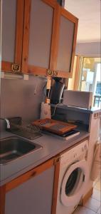 cocina con fregadero y lavadora en bel appartement avec jolie vue sur l'eau, en Cap d'Agde