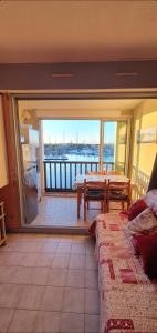 sala de estar con mesa y balcón con vistas. en bel appartement avec jolie vue sur l'eau, en Cap d'Agde