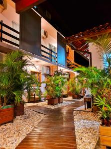 a courtyard with potted plants in a building at Origin Acomodações in Guarda do Embaú