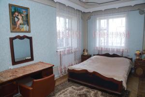 a bedroom with a bed and a mirror and a desk at Norik's Guest House in Sevan