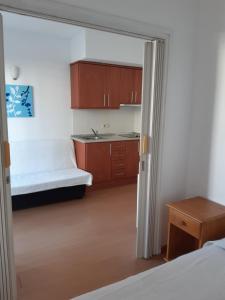 een kleine kamer met een bed en een keuken bij Apartaments Blau Park in L'Estartit