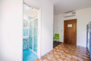 a hallway with a door to a room with a tile floor at Safestay Pisa Centrale in Pisa