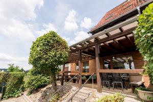 Casa con porche de madera con mesa y sillas en Gasthaus Dernedde en Osterode