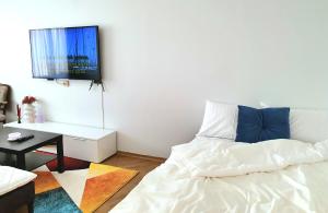 a living room with a bed and a flat screen tv at Lovely 2-bedroom Flat in Šiauliai in Šiauliai