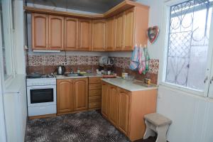 una pequeña cocina con armarios de madera y una ventana en Norik's Guest House, en Sevan