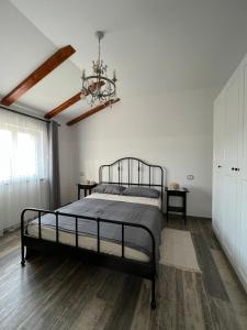 1 dormitorio con cama y lámpara de araña en Hisa STERNA - WELL HOUSE, en Zgornje Škofije