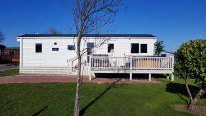 a white mobile home with a porch and a deck at 3 bed Retreat with Hot Tub in Felton