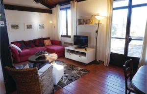 een woonkamer met een rode bank en een tv bij Beautiful Home In Prades Sur Vernazobre With 2 Bedrooms, Wifi And Outdoor Swimming Pool in Prades-sur-Vernazobre