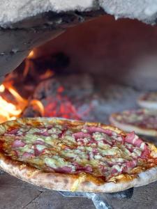 a pizza is coming out of an oven at Hotel Guri Shengjin in Lezhë