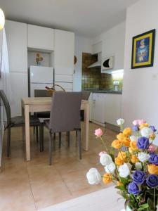 uma cozinha e sala de jantar com mesa e flores em Apartamento Oasis Park em Denia